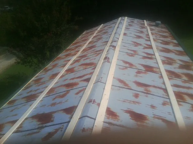 Rusted metal roof panels with new wood purlins before replacement — Storm Damage Roof Repair in Le Roy by Roofing Brothers